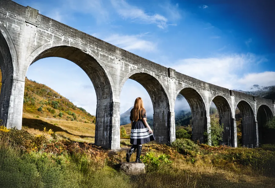 The curving stone arches of the Glenfinnan Viaduct in the Scottish Highlands.